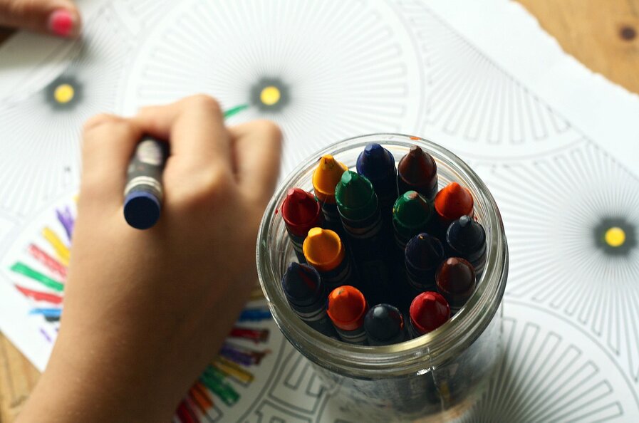 Tablet showing a beginner coloring techniques ebook beside colored pencils